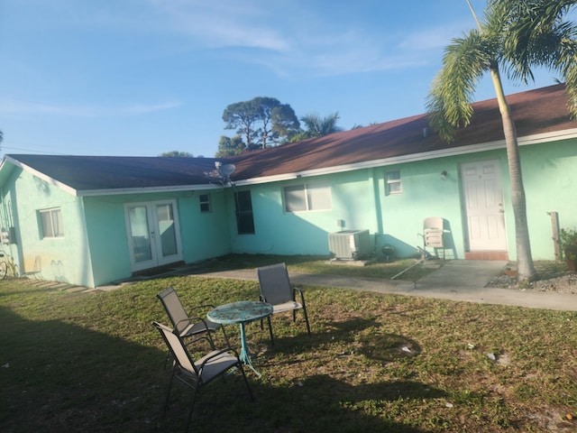 back of house featuring ac unit, french doors, and a lawn