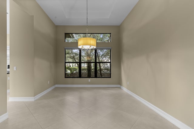 unfurnished dining area featuring a raised ceiling and light tile patterned flooring