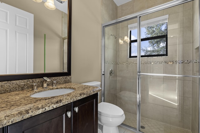 bathroom featuring walk in shower, vanity, and toilet