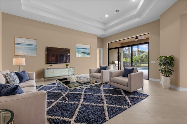 tiled living room featuring a tray ceiling