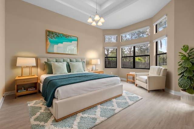 bedroom with a chandelier and light wood-type flooring