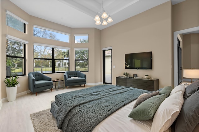 bedroom with a chandelier and light hardwood / wood-style floors