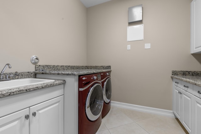 laundry area with sink, washer and clothes dryer, cabinets, and light tile patterned flooring