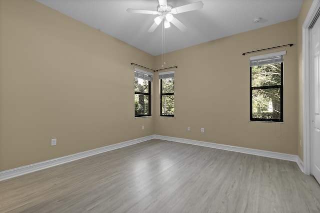 empty room with ceiling fan, light hardwood / wood-style floors, and a wealth of natural light