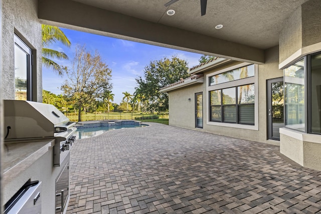 view of patio / terrace with ceiling fan, a grill, and exterior kitchen