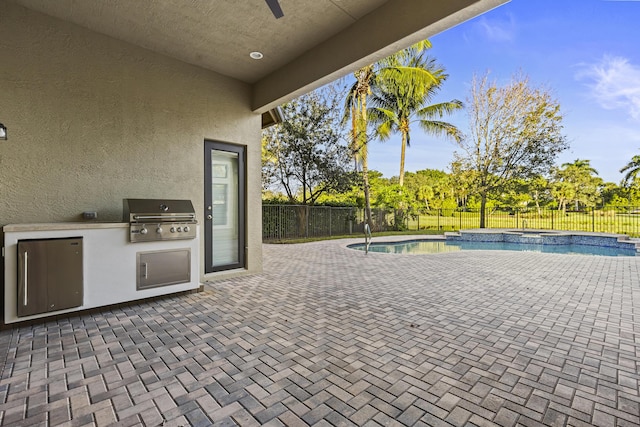 view of patio featuring an outdoor kitchen, grilling area, and a fenced in pool