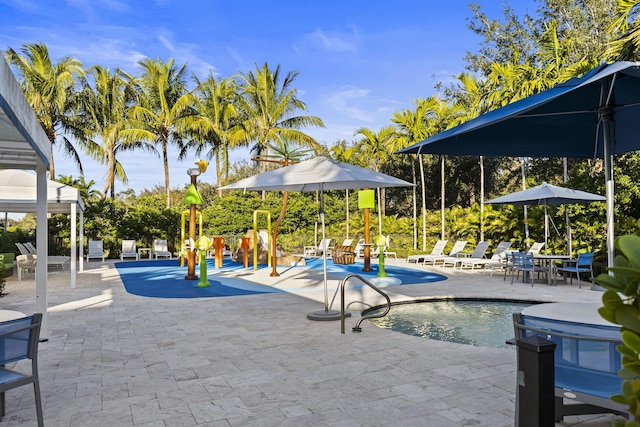 view of pool featuring a playground and a patio area