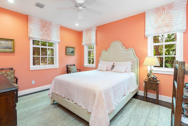 bedroom featuring multiple windows, ceiling fan, and hardwood / wood-style flooring