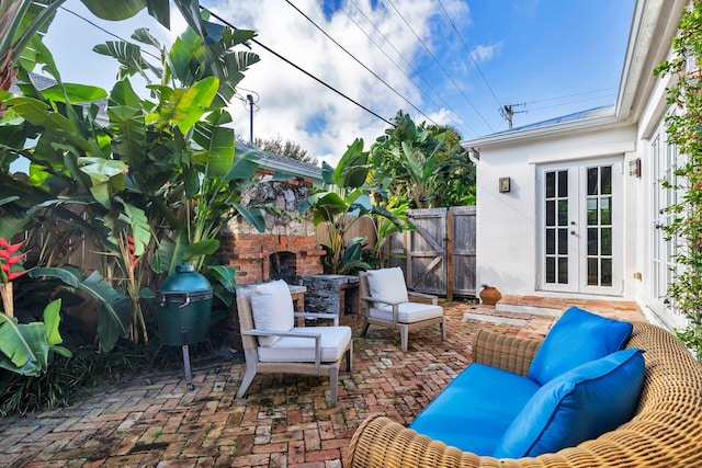 view of patio featuring an outdoor living space with a fireplace and french doors