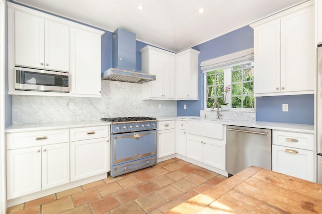 kitchen featuring white cabinets, stainless steel appliances, and wall chimney exhaust hood