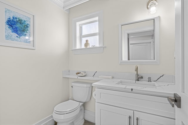 bathroom with vanity, toilet, and ornamental molding