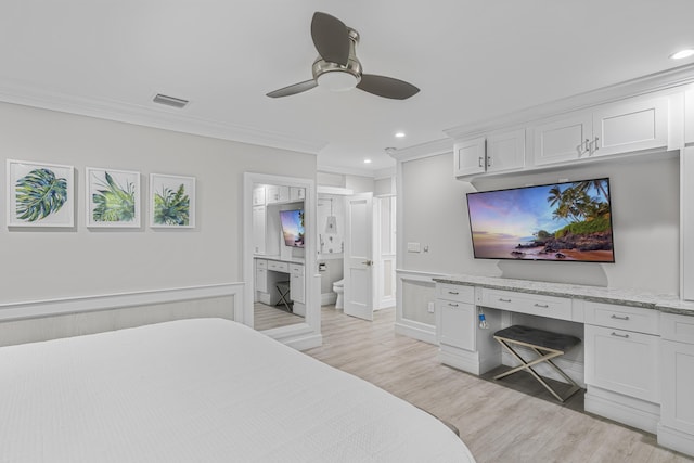 bedroom featuring light hardwood / wood-style flooring, ensuite bath, ceiling fan, and ornamental molding