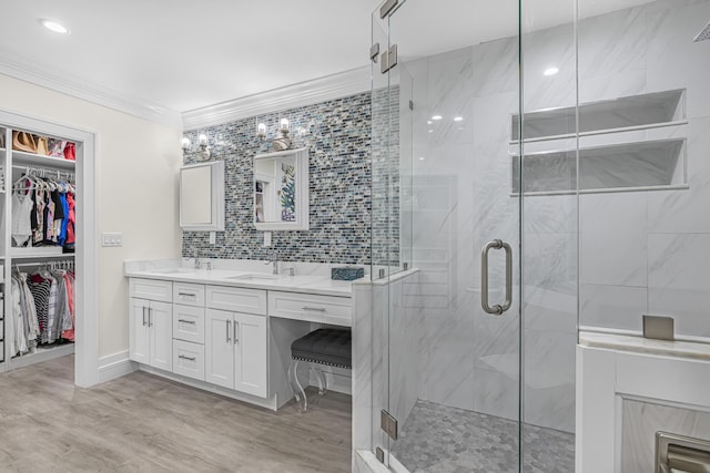 bathroom featuring ornamental molding, vanity, hardwood / wood-style flooring, and a shower with shower door