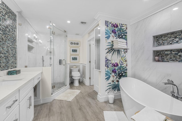 full bathroom featuring hardwood / wood-style floors, vanity, toilet, ornamental molding, and independent shower and bath