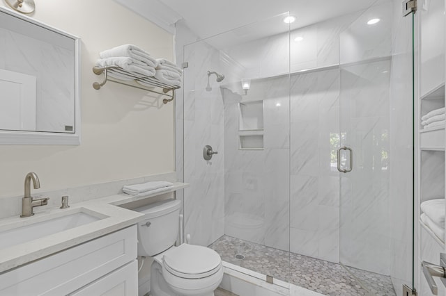 bathroom with vanity, toilet, and a shower with door