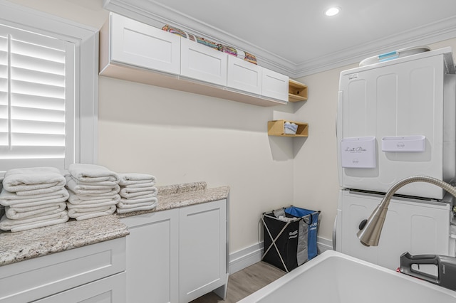 clothes washing area featuring light wood-type flooring and crown molding