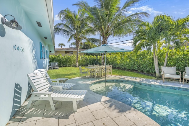 view of swimming pool featuring a patio, central AC unit, and a lawn