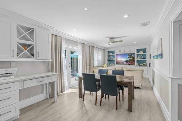 dining room featuring ceiling fan, built in features, crown molding, and light hardwood / wood-style flooring