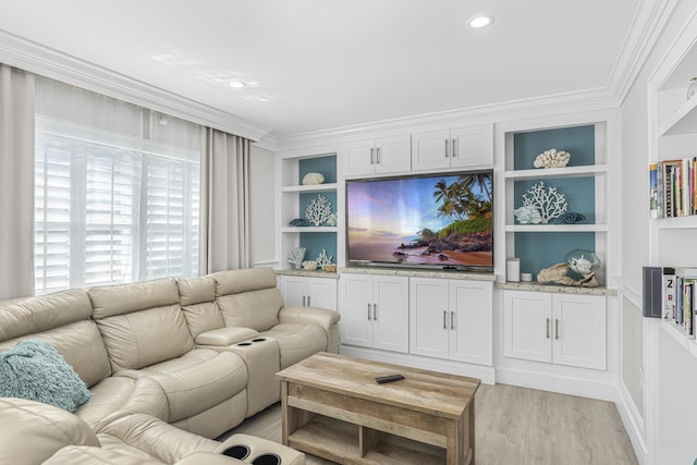 living room with built in shelves, crown molding, and light wood-type flooring