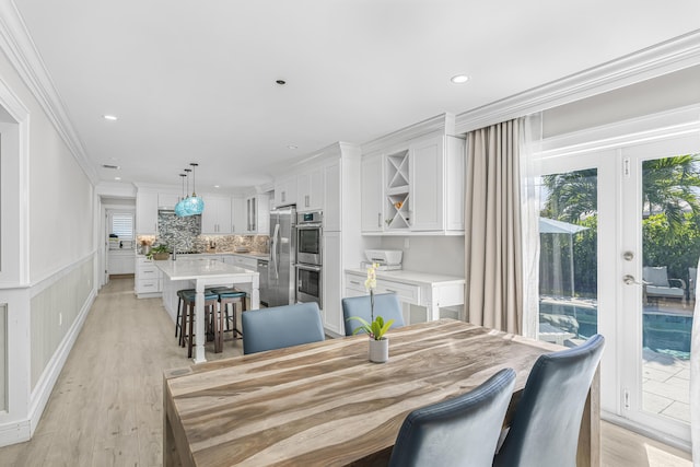 dining area featuring crown molding and light hardwood / wood-style flooring