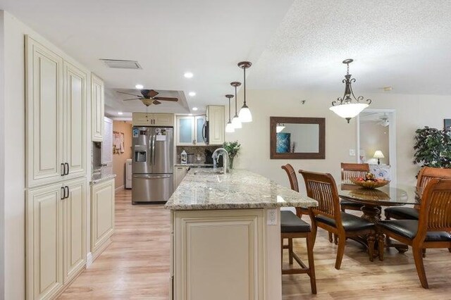 kitchen featuring pendant lighting, light wood-type flooring, stainless steel appliances, and ceiling fan