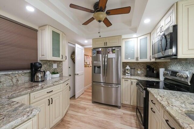 kitchen featuring backsplash, light stone countertops, and stainless steel appliances