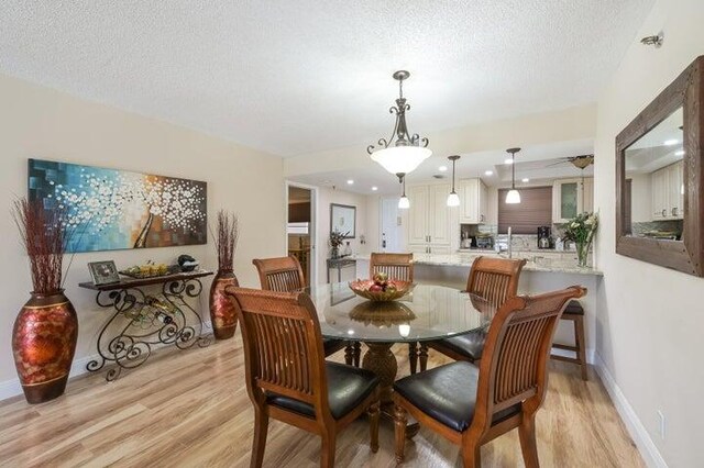 dining space with a textured ceiling and light wood-type flooring