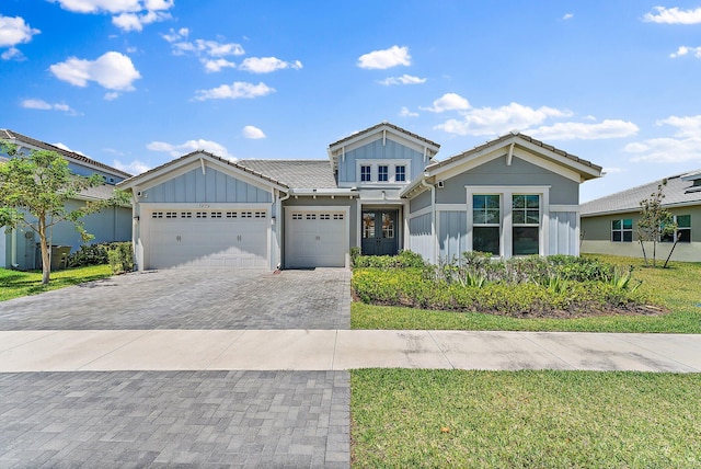 view of front facade with a front yard, french doors, and a garage