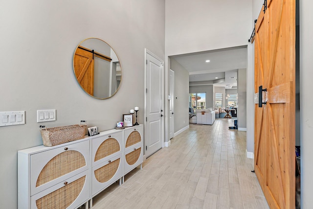 entryway featuring a barn door and light hardwood / wood-style floors