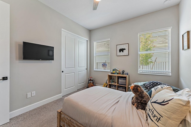 carpeted bedroom featuring ceiling fan and a closet