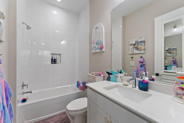 full bathroom with tiled shower / bath, vanity, and toilet