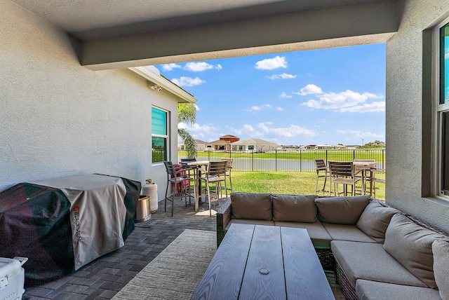 view of patio / terrace with an outdoor living space, area for grilling, and a water view