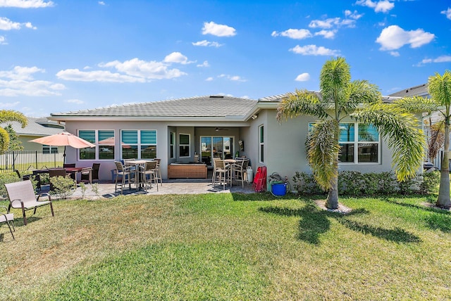 rear view of property featuring a lawn, ceiling fan, a patio area, and outdoor lounge area