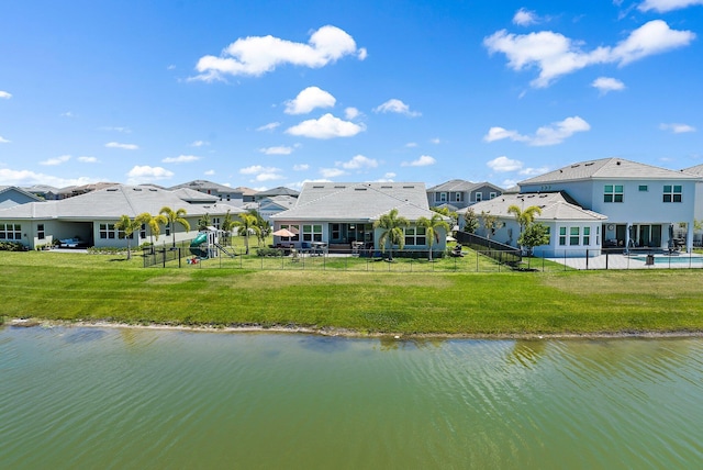 back of house featuring a yard and a water view