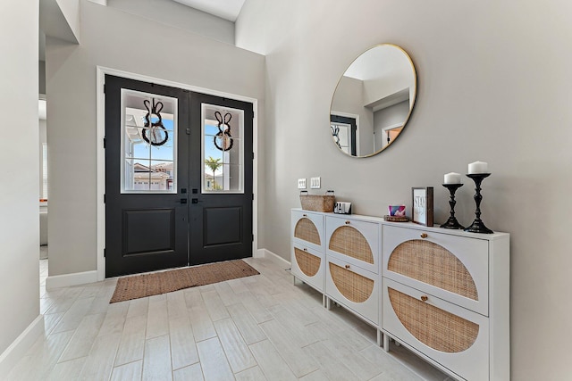 foyer entrance featuring french doors and light hardwood / wood-style floors