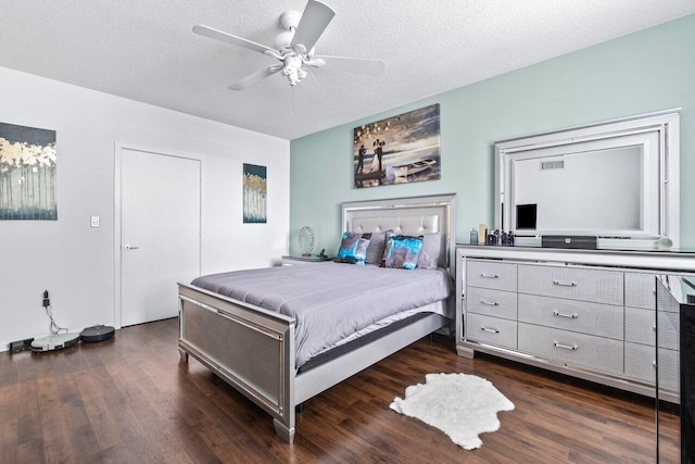 bedroom featuring ceiling fan, dark hardwood / wood-style flooring, and a textured ceiling