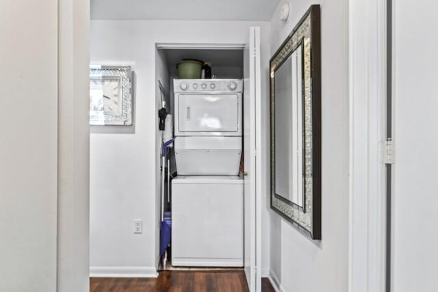 laundry area featuring dark hardwood / wood-style floors and stacked washer / drying machine