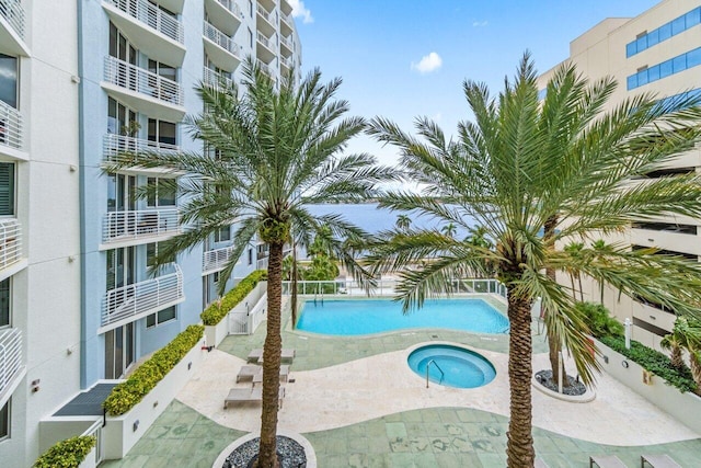 view of swimming pool featuring a hot tub