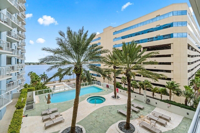 view of swimming pool with a patio area and a water view