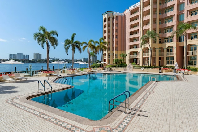 view of swimming pool featuring a water view and a patio area