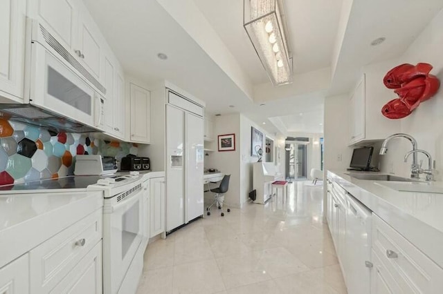 kitchen with backsplash, white appliances, a tray ceiling, sink, and white cabinets