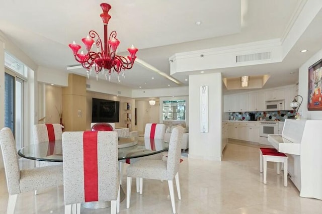 dining space featuring a tray ceiling and a notable chandelier