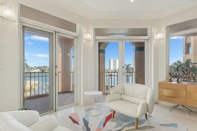 sitting room featuring a water view and french doors