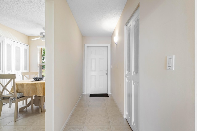 hallway featuring light tile patterned flooring and a textured ceiling