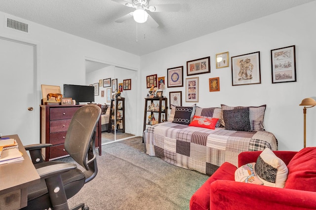 carpeted bedroom with a textured ceiling, a closet, and ceiling fan