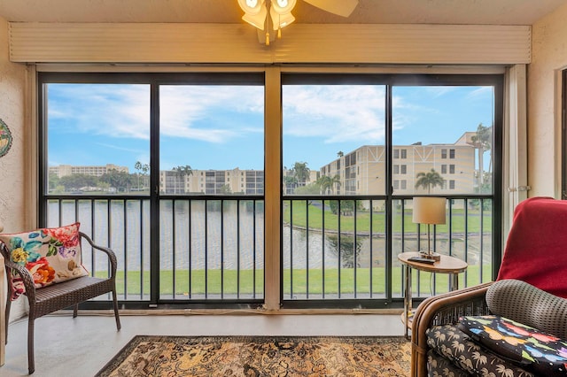 sunroom / solarium with a water view and ceiling fan