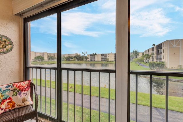 sunroom featuring a water view