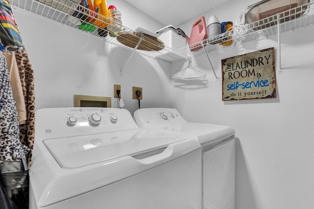 laundry room with a textured ceiling and washer and clothes dryer