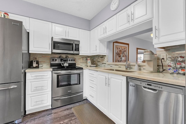 kitchen featuring white cabinets, sink, tasteful backsplash, dark hardwood / wood-style flooring, and stainless steel appliances