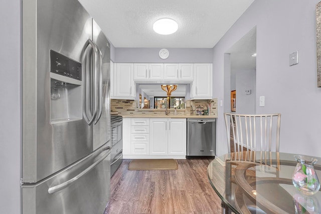 kitchen featuring white cabinetry, dark hardwood / wood-style flooring, a textured ceiling, and appliances with stainless steel finishes